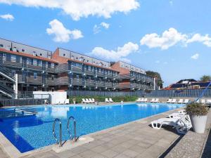 a large swimming pool in front of a building at 6 person holiday home on a holiday park in Faaborg in Fåborg