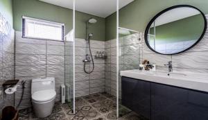 a bathroom with a toilet and a sink and a mirror at Asri loka villa in Ubud