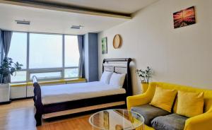 仁川市Cozy - Sunny Studio的一间卧室，里面有一张床、一张沙发和一张桌子