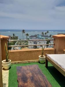 een balkon met een tafel en uitzicht op de oceaan bij Beach View Holiday Home in Mombasa