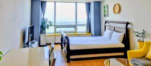 仁川市Cozy - Sunny Studio的一间卧室，里面有一张床、一张桌子和一张沙发 更多2张照片