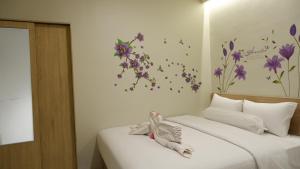 a bedroom with two beds with flowers on the wall at The One Residence Tanah Abang in Jakarta