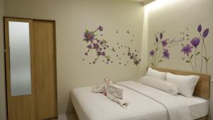 a bedroom with a bed with flowers on the wall at The One Residence Tanah Abang in Jakarta