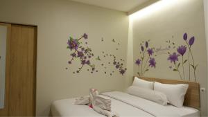 a bedroom with a bed with purple flowers on the wall at The One Residence Tanah Abang in Jakarta