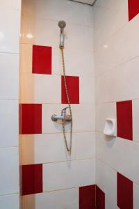 y baño con ducha de azulejos rojos y blancos. en Brothers Inn Solo Baru, en Temulus