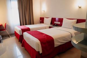 Una habitación de hotel con dos camas con sábanas rojas y blancas. en Brothers Inn Solo Baru, en Temulus 39 fotos más