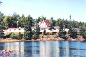 a large house on the shore of a lake at Redclyffe Shore Motor Inn in Robbinston +36 photos