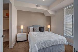 Un dormitorio con una cama con dos mesitas de noche y dos lámparas. en Spacious 2-Bedroom Urban Oasis, en Salt Lake City