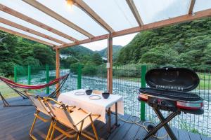 a screened in porch with a grill and a table and chairs at SPRINGS VILLAGE Ashigara Tanzawa Onsen Resort & Gl - Vacation STAY 41906v in Hata +9 photos