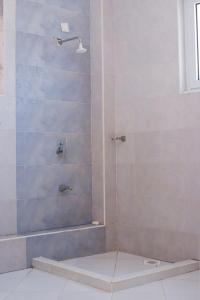 een douche met een glazen deur in een badkamer bij Beach View Holiday Home in Mombasa