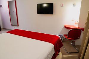 Un dormitorio con una cama, un escritorio y un televisor. en Brothers Inn Solo Baru, en Temulus