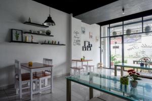 a dining room with a glass table and chairs at Urbanview Hotel Double Tree near RSUD Margono Purwokerto in Purwokerto +59 photos