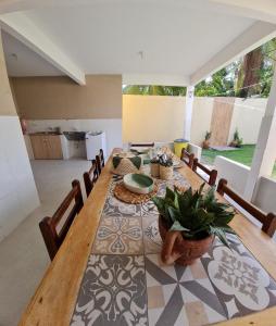 ein Esszimmer mit einem langen Holztisch und Stühlen in der Unterkunft Casa do Bougainvillea Mundaú-Trairi-Ce in Mundaú