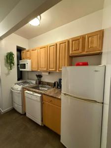 Una cocina con gabinetes de madera y un refrigerador blanco. en Delux Room by Times Square, en Nueva York