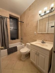 Un baño con inodoro, lavabo y bañera. en Delux Room by Times Square, en Nueva York