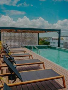 une terrasse avec des chaises et une piscine dans l'établissement Zuhause Apartments 5th AV, à Playa del Carmen