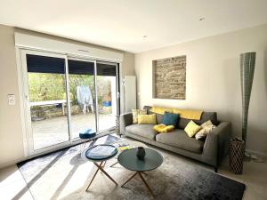 a living room with a couch and a table at Charmante maison à Groix proche du port - FR-1-813-35 in Kerlo +1 photo