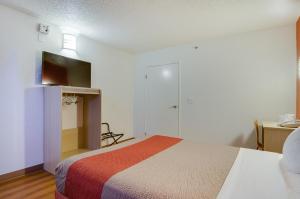 塔科馬的住宿－塔科馬南部6號汽車旅館，一间卧室配有一张床、一张书桌和一台电视。
