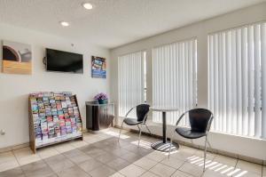 a waiting room with chairs and a table and a tv at Motel 6-Tacoma, WA - South in Tacoma