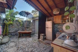a kitchen with a refrigerator and a table with an umbrella at Gedong Batu Villas in Ubud