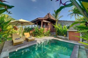 a villa with a swimming pool and a house at Gedong Batu Villas in Ubud