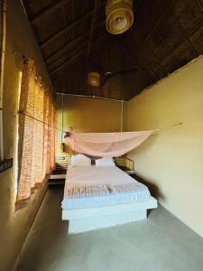 a bedroom with a bed with a mosquito net at The Cottage Core Village in Borās
