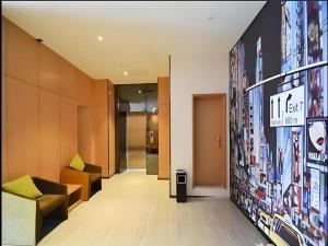 een lobby van een gebouw met een bord aan de muur bij IU Hotel Zhengzhou Xinzheng Sias International University Branch in Xinzhengzhan