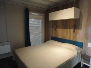 une petite chambre avec un lit et une fenêtre dans l'établissement Chalet neuf avec piscine couverte, proche mer, calme et sécurisé - 6 personnes - FR-1-777-8, à La Parée Preneau 3 autres photos