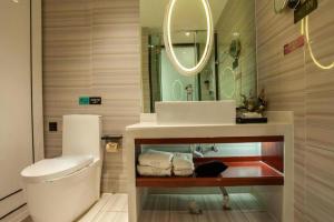 ein Badezimmer mit Waschbecken, Toilette und Spiegel in der Unterkunft Xana Lite Korla Shihua Avenue Longquehe in Korla