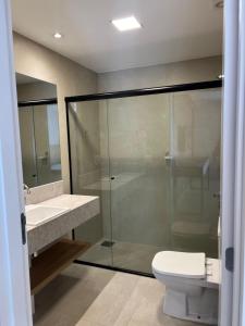 a bathroom with a glass shower and a toilet at Alugueasy - EASY Noroeste in Brasília +34 photos