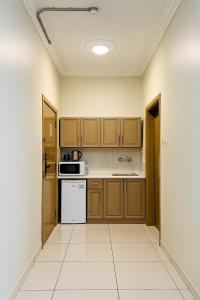 a kitchen with wooden cabinets and a white appliance at فندق تلاق للخدمات الفندقيه in Medina