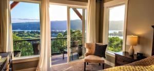 een slaapkamer met een bed, een bureau en grote ramen bij Panoramic River Views - Nature Framed in Every Window in Kalama