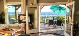 een woonkamer met een balkon met een tafel en een parasol bij Panoramic River Views - Nature Framed in Every Window in Kalama