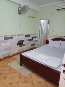 a bedroom with a bed in a room with tiles at Quang Linh Motel Thanh Hóa in Thanh Hóa