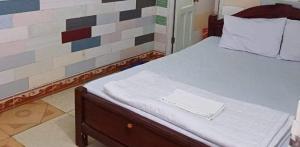 a bed in a room with a brick wall at Quang Linh Motel Thanh Hóa in Thanh Hóa