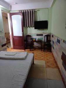 a room with a bed and a tv and a door at Quang Linh Motel Thanh Hóa in Thanh Hóa