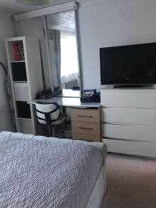 een slaapkamer met een bed en een bureau met een televisie bij Quaint and Peaceful - Calne in Calne