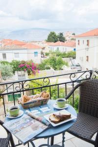 einen Tisch mit Brot und zwei Tassen auf einem Balkon in der Unterkunft Filoxenia Studios in Galaxidi