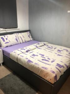 a bed with a comforter on it in a bedroom at Quaint and Peaceful - Calne in Calne