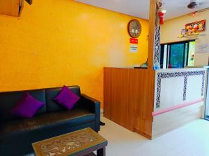 a living room with a couch and a clock on a wall at Hotel P I international in Mumbai