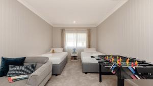 a living room with a table with a chess board on it at Waterfront, Renovated, Walk To Ettalong in Pretty Beach