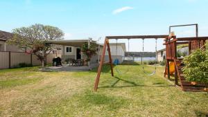 a swing set in the yard of a house at Waterfront, Renovated, Walk To Ettalong in Pretty Beach +16 photos