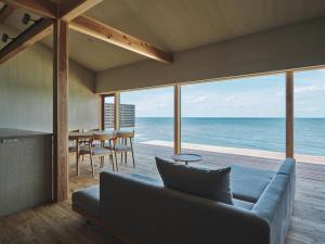 Una sala de estar con un sofá y vista al mar. en 青々 -aoao-, en Taisya