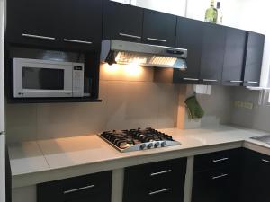 une cuisine avec une cuisinière et un micro-ondes dans l'établissement Casa frente al mar, à Playas