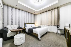 a hotel room with a bed and a chair at Modern Business Hotel in Gumi +52 photos
