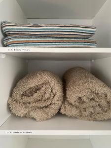 dos toallas sentadas en un estante en un armario en Allawah at Wamberal, en Wamberal