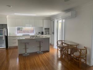 Una cocina con encimera, mesa y sillas. en Allawah at Wamberal, en Wamberal