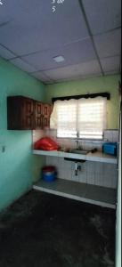 um quarto com uma cozinha com um lavatório e uma janela em Residencia Sánchez em David