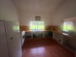 a kitchen with a white refrigerator and two windows at Casa Nueva Holanda in Las Vigas