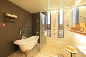 un baño con bañera y ducha de cristal en Najima B&B, en Jian 148 fotos más